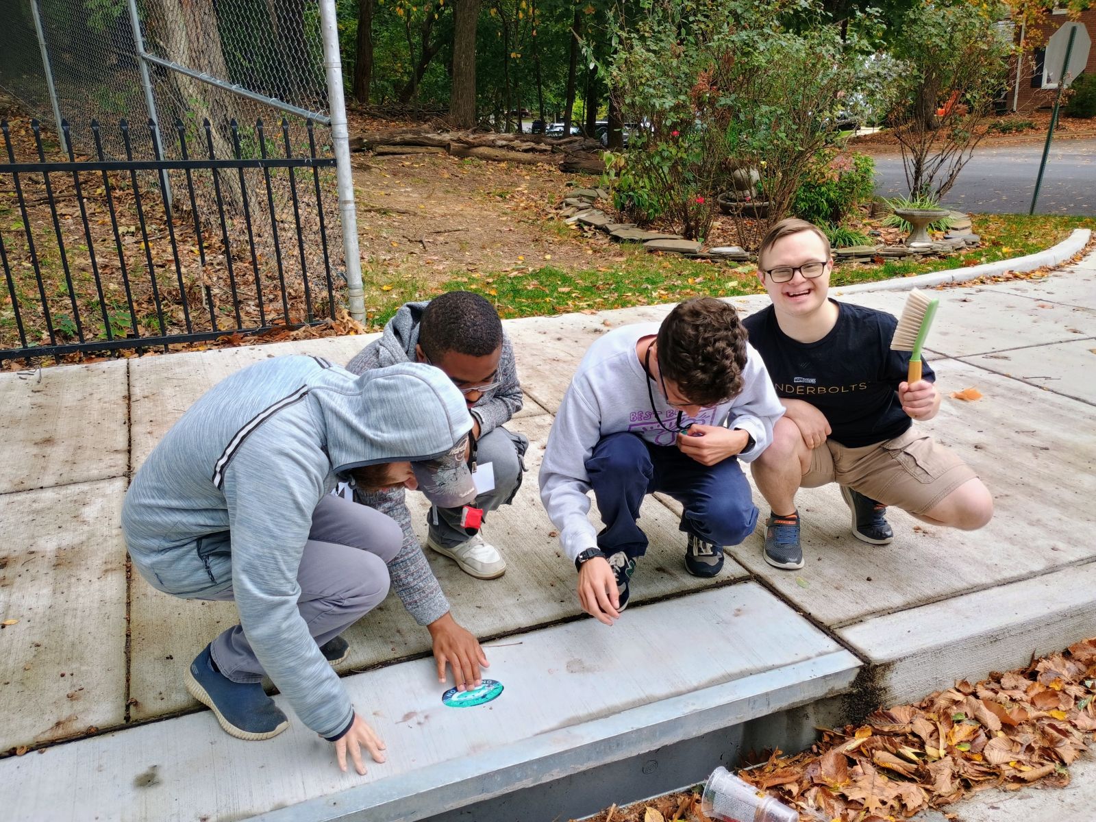 four Arlington Access program participants placing down a storm drain marker